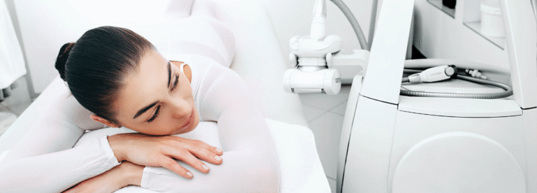 A client in a white treatment suit lies beside an LPG endermologie device and roller handpiece.