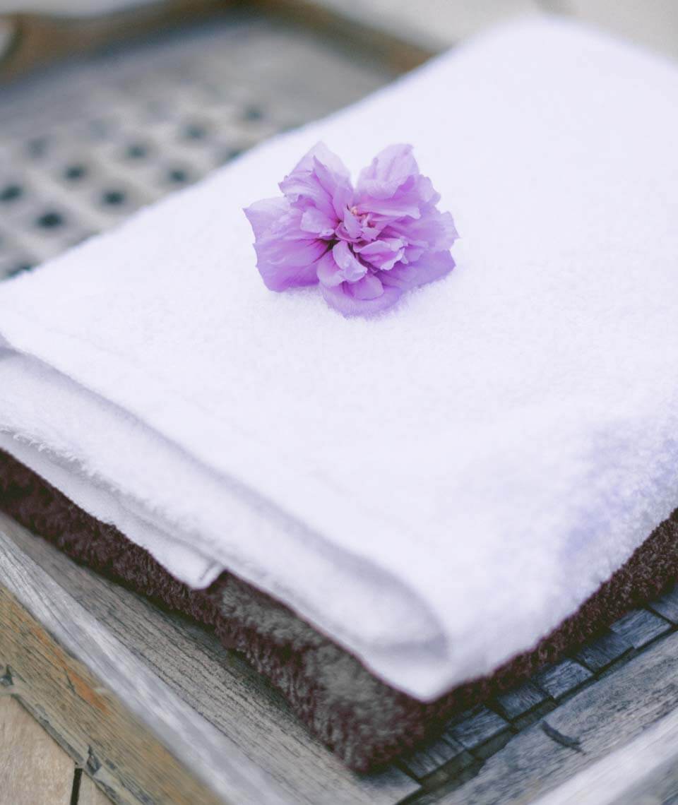 A folded spa towel with a single flower, a quiet studio detail.