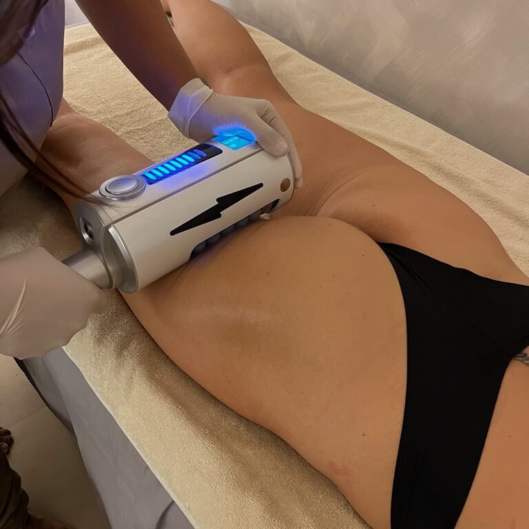 A therapist uses an Endospheres roller handpiece on a client’s hip and upper thigh.
