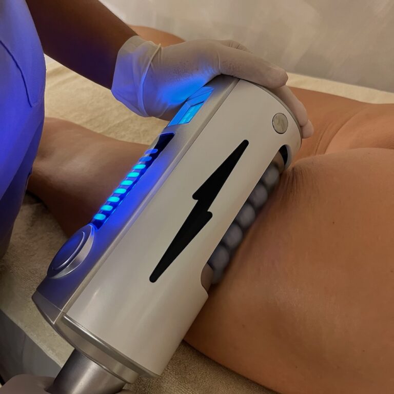 A therapist uses an Endospheres roller handpiece on a client's thigh.