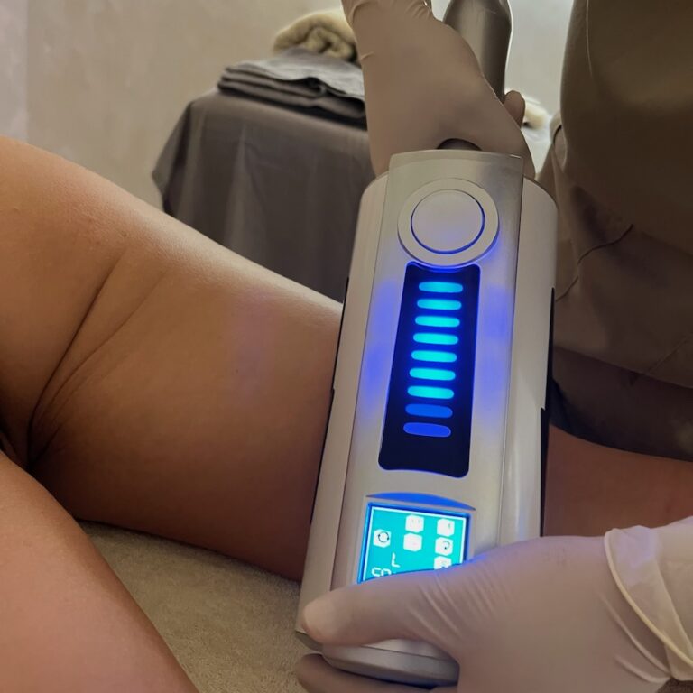 A therapist applies an Endospheres handpiece to a client’s thigh.