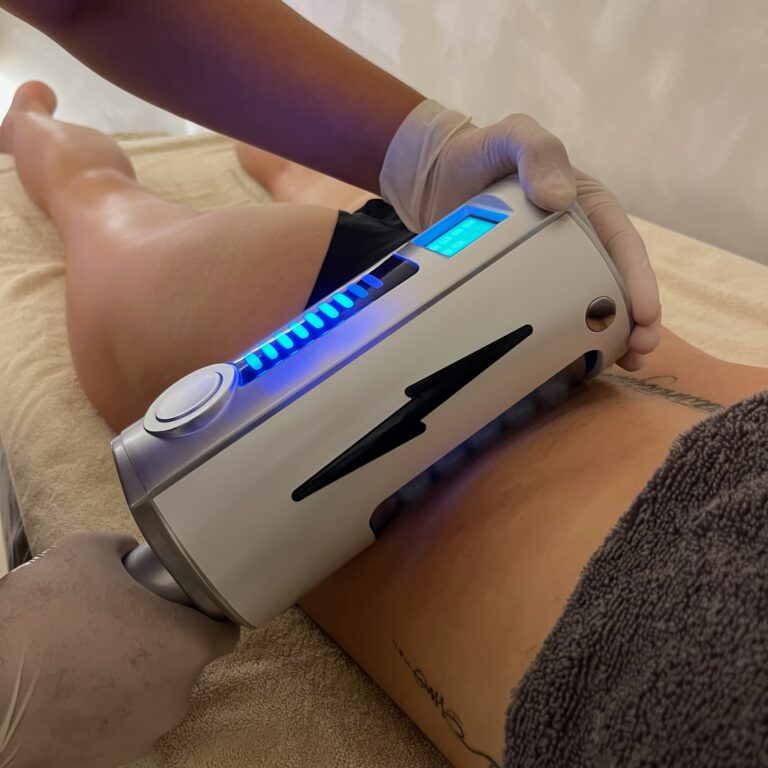 A therapist uses an Endospheres roller handpiece on a client's upper thigh.