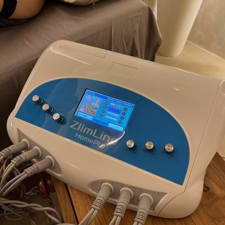 A cold lipo laser control unit is set up beside a treatment bed.