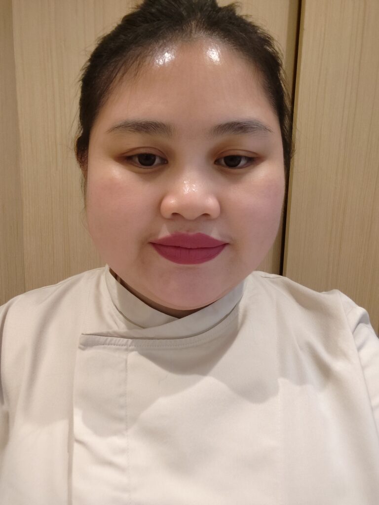 흰색 유니폼을 입고 카메라를 바라보는 스튜디오 직원.