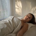 A client resting after a lymphatic body treatment in a bright Bali studio, soft afternoon light